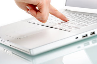 Laptop with person pushing a button on the keyboard